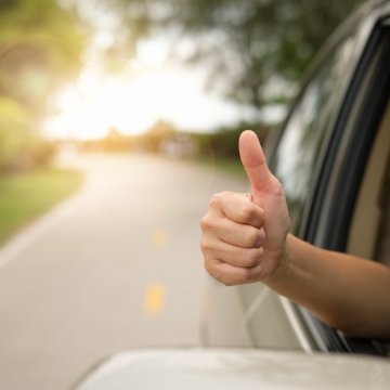 autopom, extended car warranty, car insurance, vehicle protection, benefits, hand giving the okay sign from car on the road, sunny background